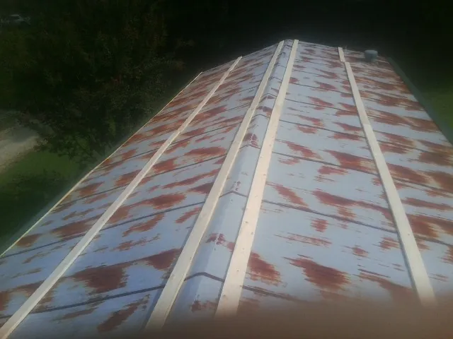 Rusted metal roof panels with new wood purlins before replacement — Storm Damage Roof Repair in Campus by Roofing Brothers
