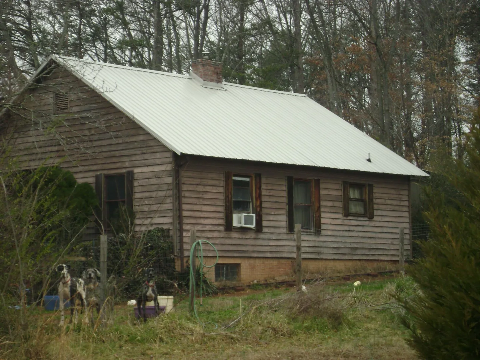 White metal roof on an old wood sided farmhouse, from a Metal Roof Installation job in Campus